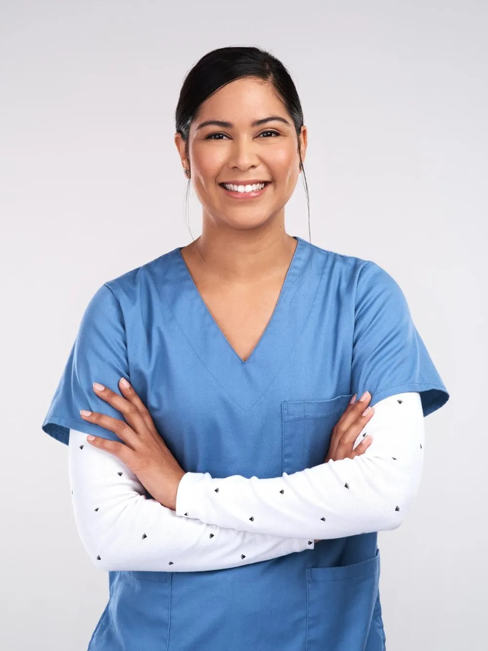 portrait-beautiful-young-doctor-standing-with-arms-folded-against-white-background-edited